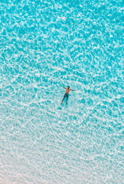 man floating alone in clear ocean water
